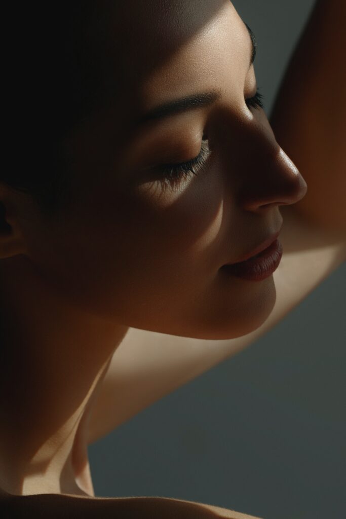 Young woman closing her eyes smiling and showing toned figure after neck lift recovery with Dr. John Diaz in Beverly Hills, Los Angeles