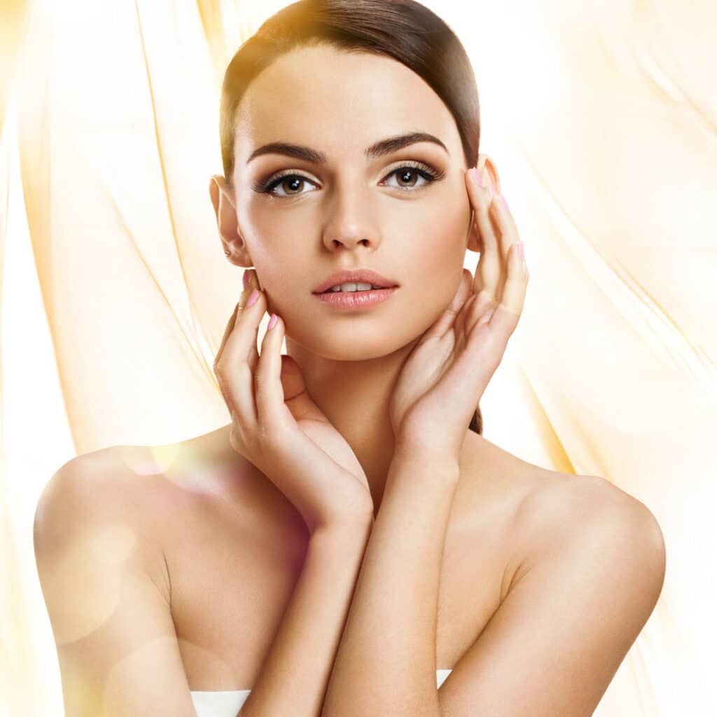 Photo of a beautiful woman with her hands on her face, showing off her flawless skin